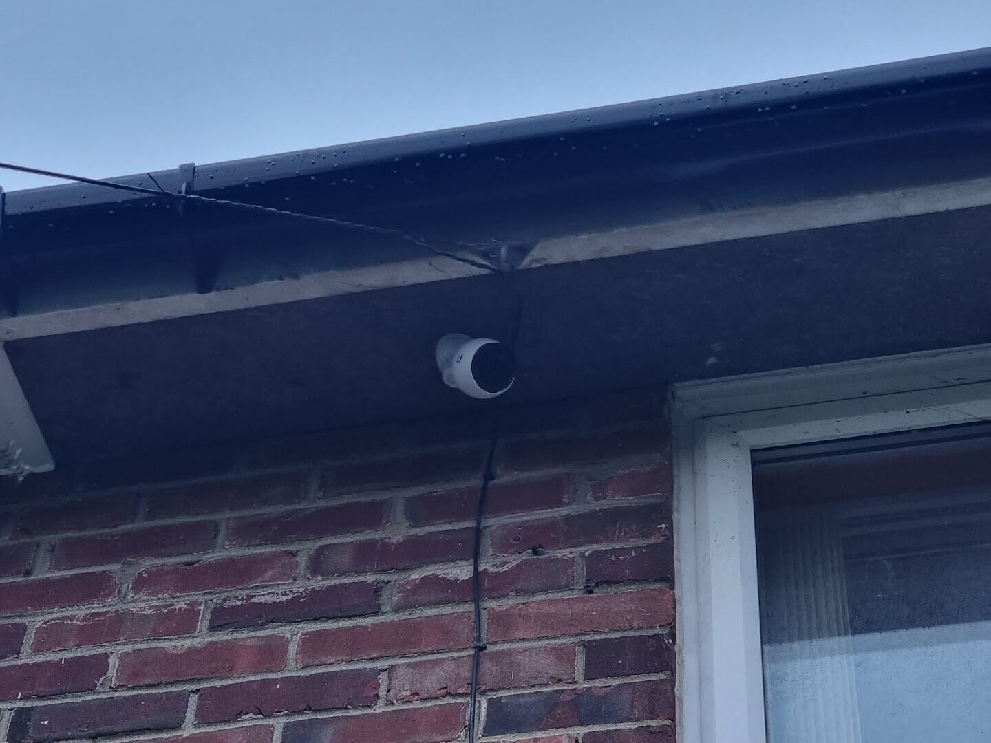 Outdoor CCTV camera securely installed on residential property for home security system upgrade by professional IT technicians